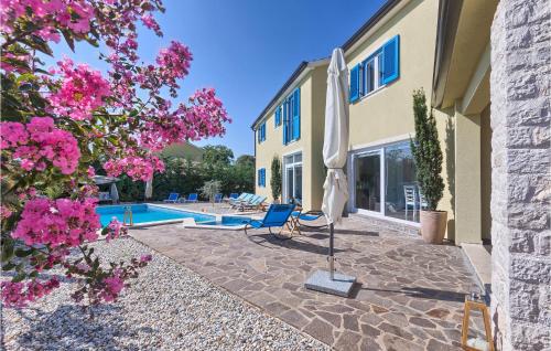 une villa avec piscine et patio avec parasol dans l'établissement Awesome Home In Naselje Muzini, à Tomišići