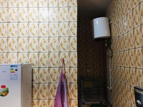 a kitchen with a refrigerator and a tile wall at Résidence D B in Yaoundé
