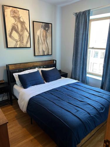 a bedroom with a bed with blue sheets and a window at Dorothy's in Chicago