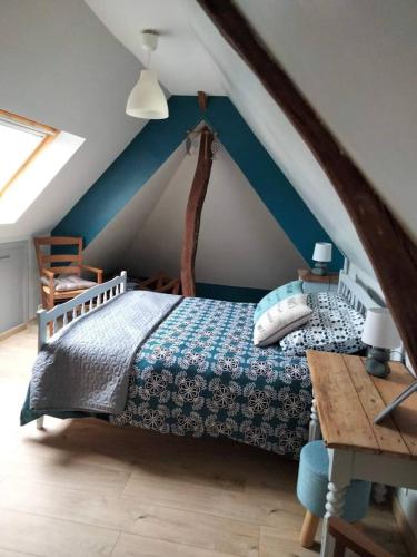 une chambre avec un lit dans un grenier dans l'établissement Maison accueillante à Petit-Caux avec jardin, à Tocqueville-sur-Eu
