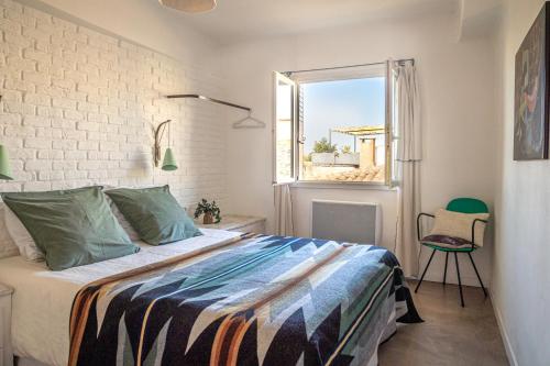 a bedroom with a bed and a window at Le 40 in LʼIsle-sur-la-Sorgue