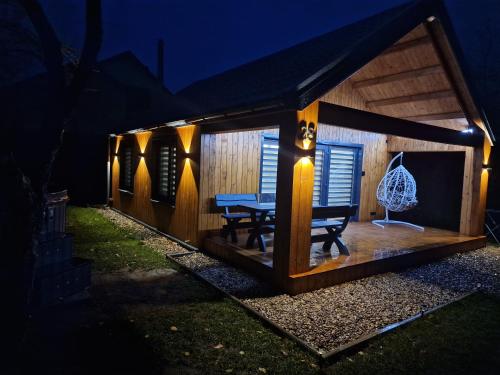 a small house with a table in it at night at Naujai įrengtas atostogų namelis in Anykščiai