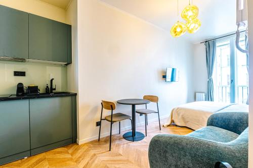 Il comprend une cuisine et un salon avec un lit et une table. dans l'établissement Studio Design Neuf - Central, à Paris