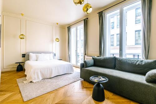 un salon avec un canapé et un lit dans l'établissement Luxurious Paris Loft Near Opéra, à Paris
