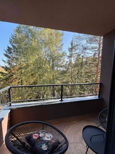 a balcony with a table and chairs and a large window at Zlatiborske terase Spa&Wellness in Zlatibor