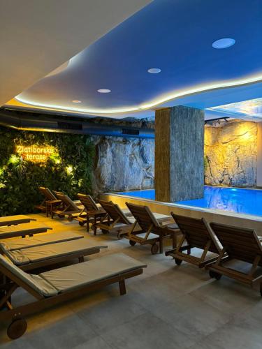 a restaurant with tables and chairs and an aquarium at Zlatiborske terase Spa&Wellness in Zlatibor