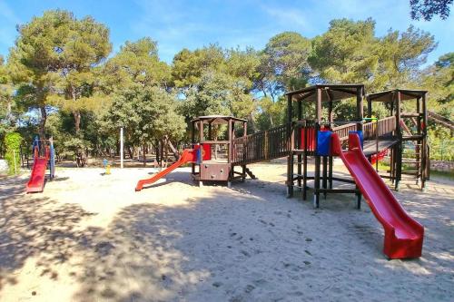 un parque infantil con tobogán y columpios en Mobile home Maris, en Biograd na Moru