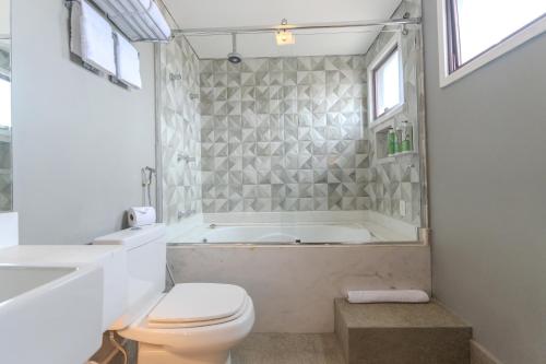a bathroom with a tub and a toilet and a sink at Hotel Heritage in Sao Paulo