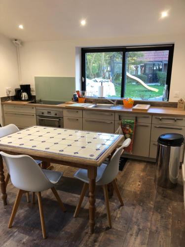 une cuisine avec une table et des chaises et une fenêtre dans l'établissement oiseau du paradis, à Illies