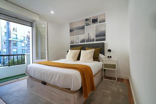 a bedroom with a large bed and a window at YBH Villa Valentina - Apartamentos Turísticos in Vilagarcia de Arousa