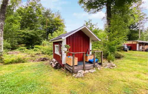 a small red shed in a grass field at Lovely Home In Örkelljunga With Kitchen in Orkelljunga