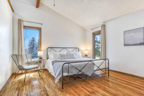 a bedroom with a bed and a chair and windows at Private Villa-72 Acres-Hot Tub-Views-USAFA in Colorado Springs