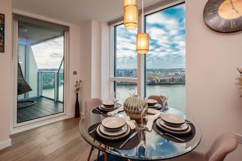 comedor con mesa de cristal y vistas a la ciudad en The Itchen River Apartments, en Southampton