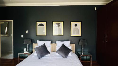 a bedroom with a black wall with a white bed at The Private Place in eMalahleni
