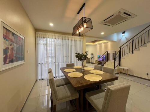 a dining room with a wooden table and chairs at RUMAH SAUJANA KLIA by IMPIAN HOMESTAY in Sepang