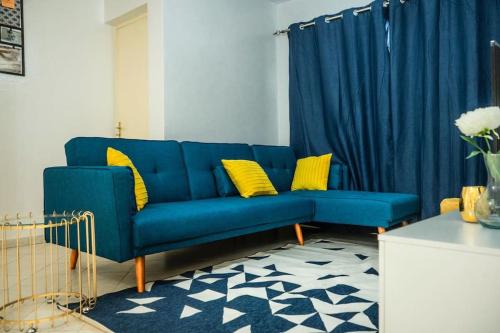 a blue couch with yellow pillows in a living room at Private Garden Villa Almadies-Ngor 3 bedrooms wifi in Dakar