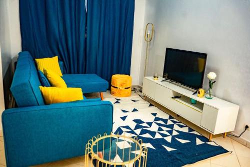 a living room with a blue couch and a tv at Private Garden Villa Almadies-Ngor 3 bedrooms wifi in Dakar
