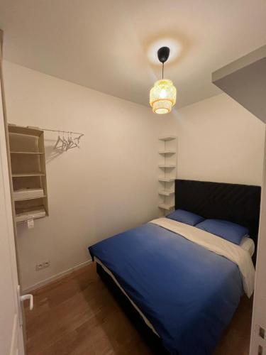 - une chambre avec un lit bleu et une lampe dans l'établissement Le Havre Montmartrois 2, à Paris