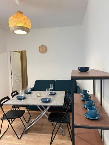 d'une salle à manger avec une table et des plats bleus. dans l'établissement Le Havre Montmartrois 2, à Paris