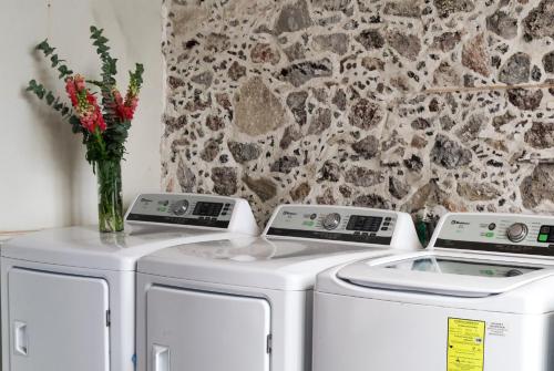 two washing machines and a vase of flowers in a room at CASA SAUTO Suite Cathedral Views in Downtown in Mexico City
