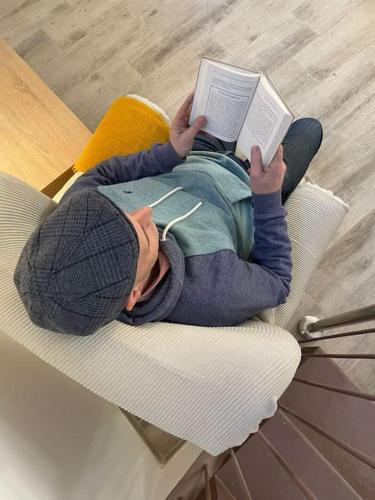 a man laying on a chair reading a book at Habitación Montgros en Casa Camí de les Aigües Monistrol de Montserrat in Monistrol