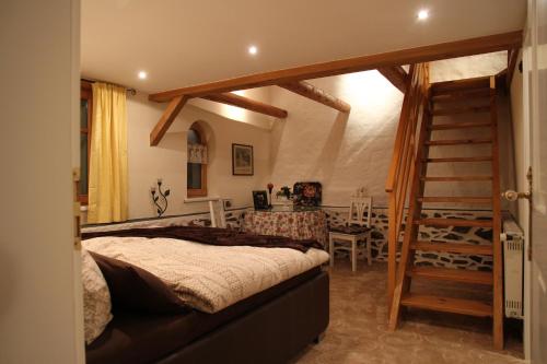 een slaapkamer met een bed, een trap en een tafel bij Alpen-suite in Riezlern
