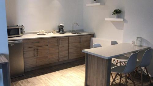 a kitchen with a counter and a table with chairs at Hotel Flamingo in Ciudad Juárez