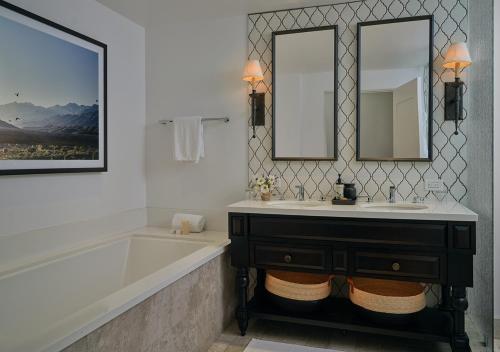 a bathroom with a tub and a sink and two mirrors at Ojai Valley Inn in Ojai