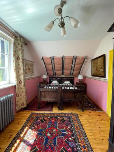a room with a bed and a rug at Willa Reglówka Stylowy dom Pachnący ogród in Wola Krakowiańska