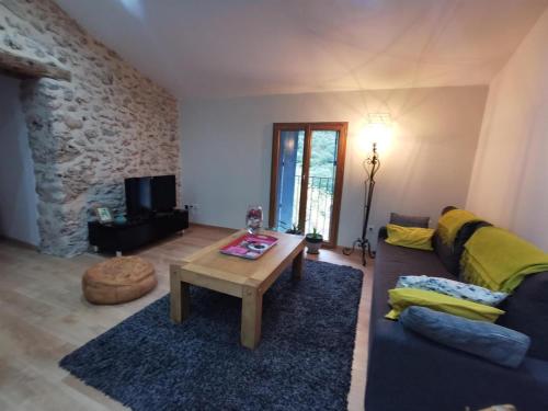 un salon avec un canapé et une table basse dans l'établissement GÎTE 3* SAINT GUILHEM LE DESERT CHEZ MARIUS, à Saint-Guilhem-le-Désert