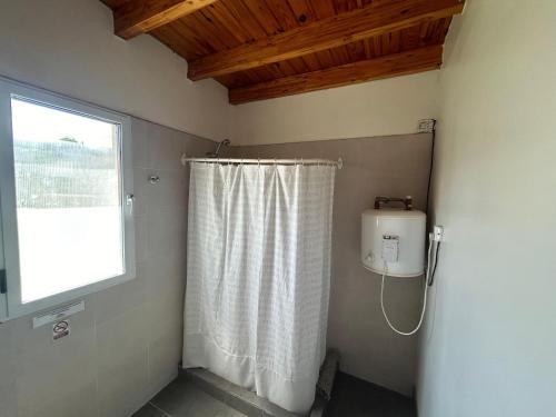 a bathroom with a shower curtain and a window at Andes cerros departamento en mendoza ciudad in El Challao