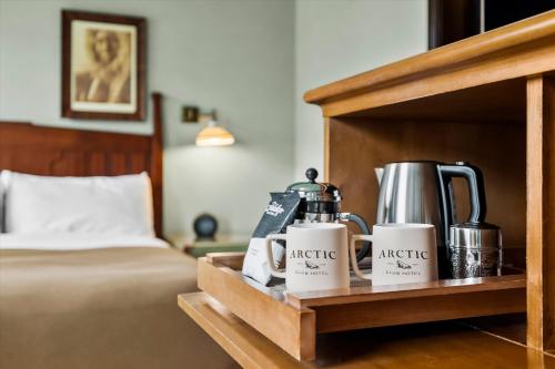 a wooden shelf with coffee cups and appliances on a bed at Arctic Club Hotel in Seattle