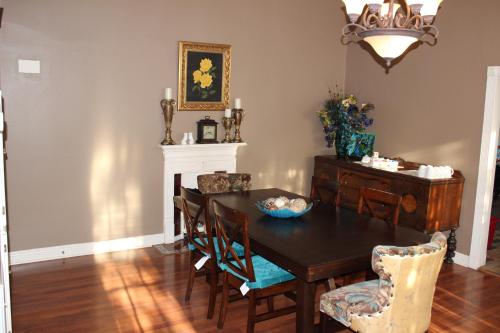 jadalnia ze stołem, krzesłami i żyrandolem w obiekcie Huffman House Bed & Breakfast w mieście Minden