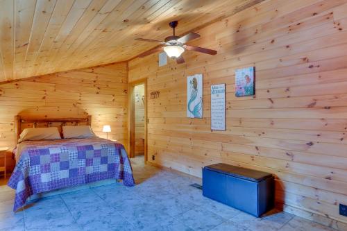 Un dormitorio en una cabaña de madera con una cama y un ventilador de techo. en 1 Mi to Current River Sunset-View Van Buren Cabin, en Van Buren