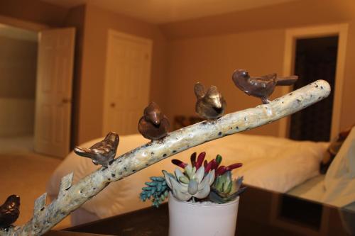 a vase with birds perched on a branch next to a bed at Huffman House Bed & Breakfast in Minden