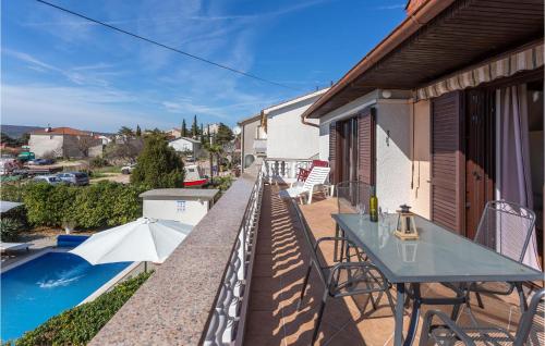 a balcony with a table and chairs and a pool at Cozy Apartment In Punat With Sauna in Punat