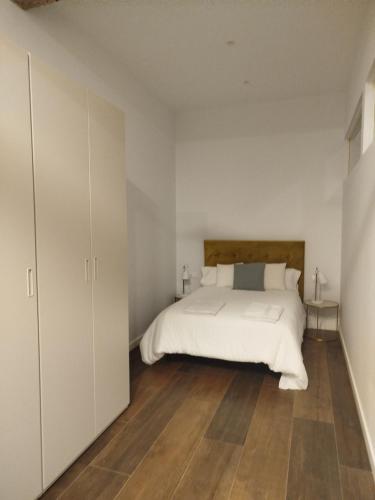 Schlafzimmer mit einem weißen Bett und Holzboden in der Unterkunft LOFT LA Santander Centro in Santander
