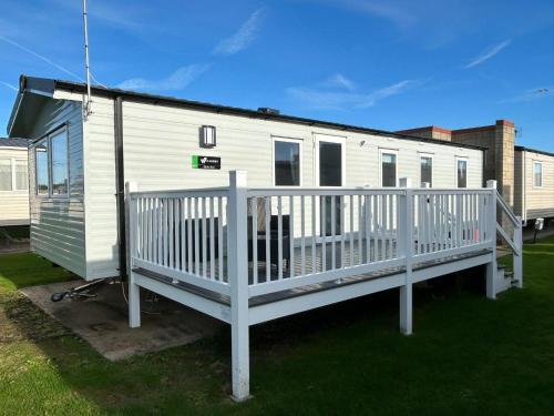 a mobile home with a porch and a deck at Beautiful 8 Berth Caravan With Decking At Naze Marine Holiday Park Ref 17344Br in Walton-on-the-Naze