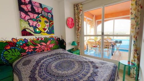 a bedroom with a bed with a painting on the wall at Casa Del Arte in Mojácar