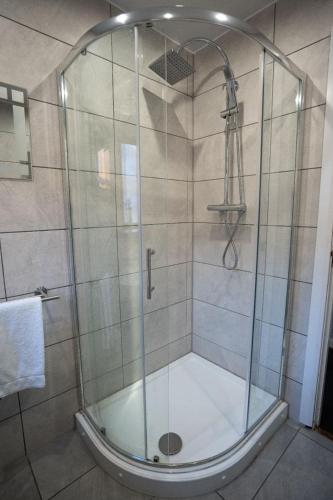 a shower with a glass door in a bathroom at One Bedroom ground floor flat in Stirling