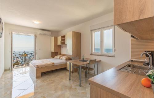 クラヴィツァにあるStudio Apartment In Krvavicaのベッドルーム1室(ベッド1台付)、キッチン(窓付)