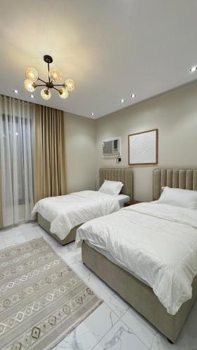 una camera da letto con due letti e un ventilatore a soffitto di وصول ذاتي Alsumo-apartment a Gedda