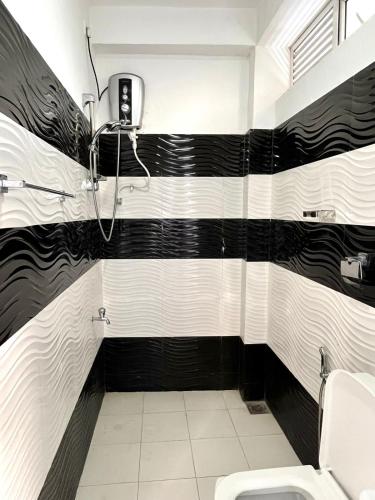 Baño con rayas blancas y negras en la pared en Sky Bliss By Mahaweli, en Kandy