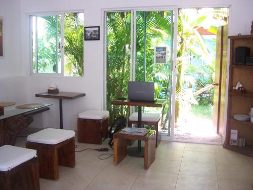 una habitación con mesas y taburetes y un ordenador portátil en una mesa en Elements of the Island, en Isla Mujeres