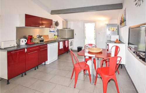 une cuisine avec des chaises rouges et une table. dans l'établissement One-Bedroom Holiday Home In Aubignan, à Aubignan