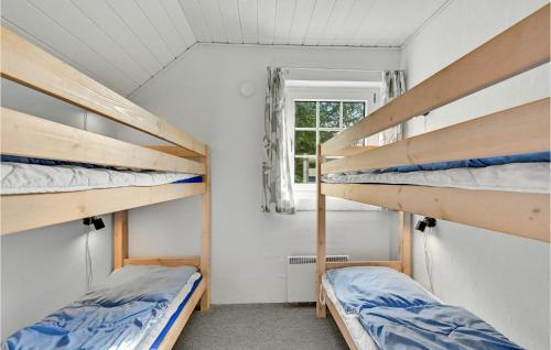 two bunk beds in a room with a window at Stunning Home In Ringkøbing With Sauna in Søndervig