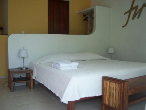 a bedroom with a white bed and a mirror at Elements of the Island in Isla Mujeres