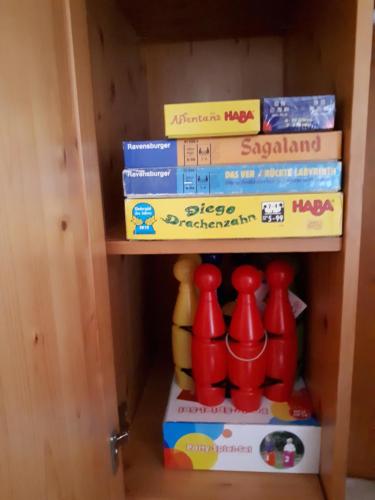 a book shelf with a bunch of books and kettles at Ferienhaus Bad Waltersdorf im Biodorf in Bad Waltersdorf