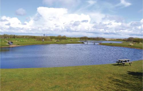 a picnic table next to a lake with a pier at Stunning Home In Ringkøbing With Sauna in Søndervig