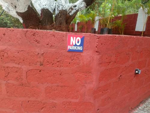a no parking sign on a red brick wall at Shantadurga Beachside Homestay in Guhagar